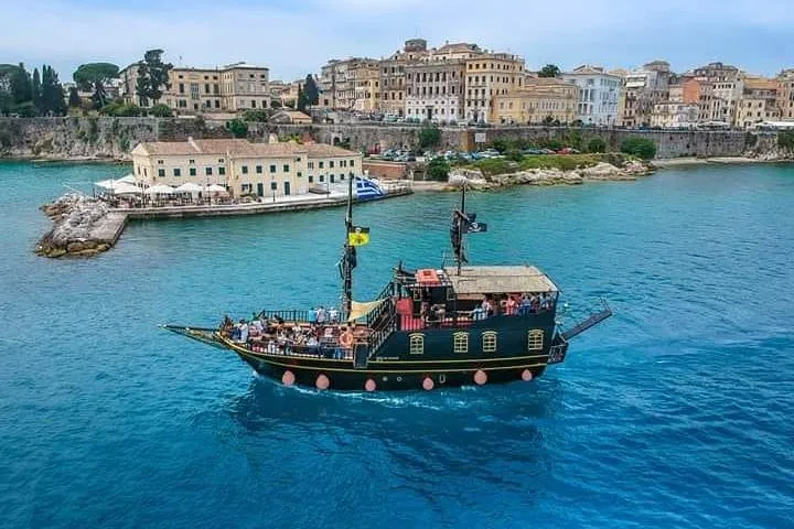 Replica pirate ship sailing below the Old Fortress on a family Corfu boat tour from the Old Port